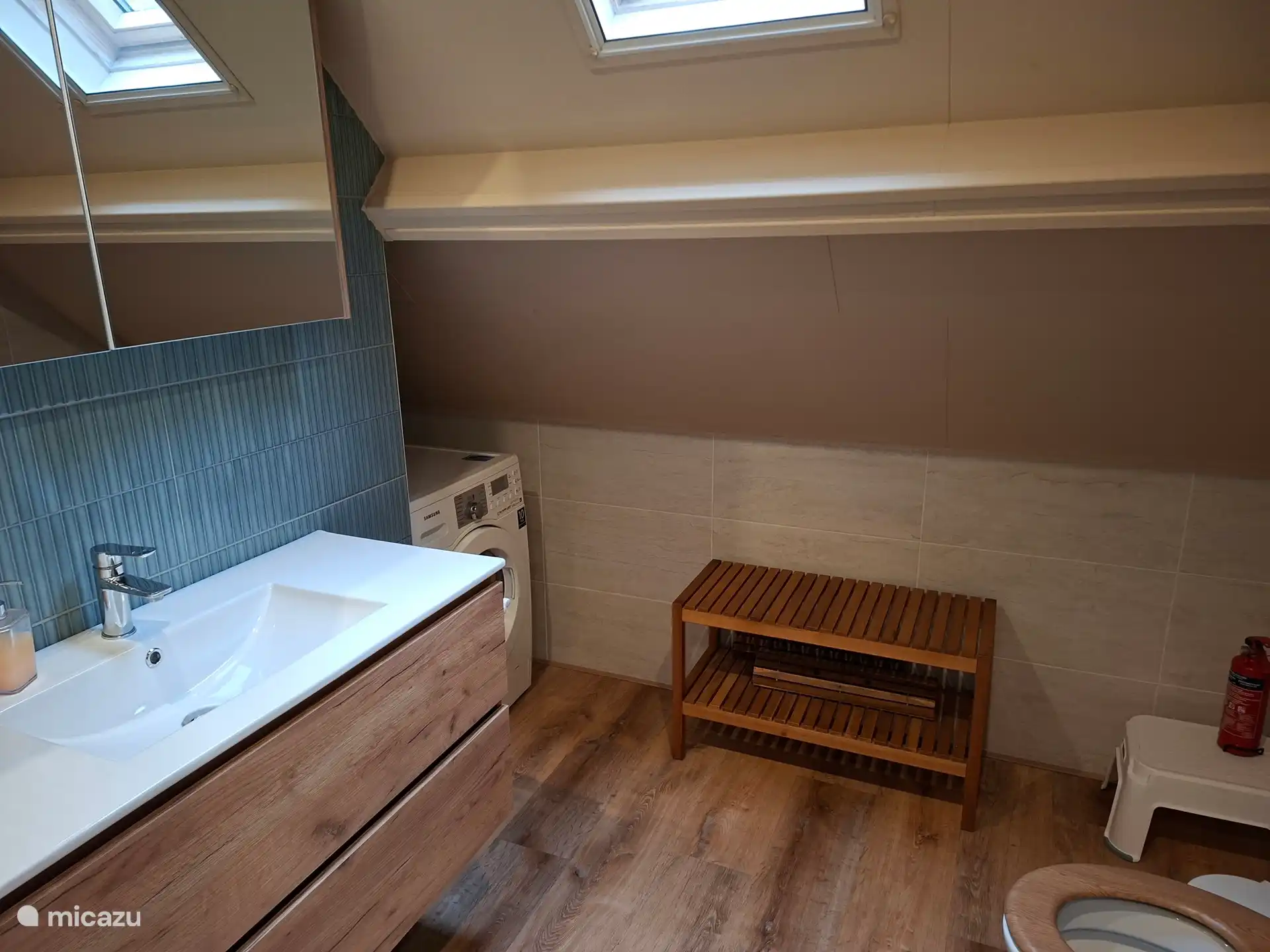 Toilet op de badkamer; in de hoek de wasmachine