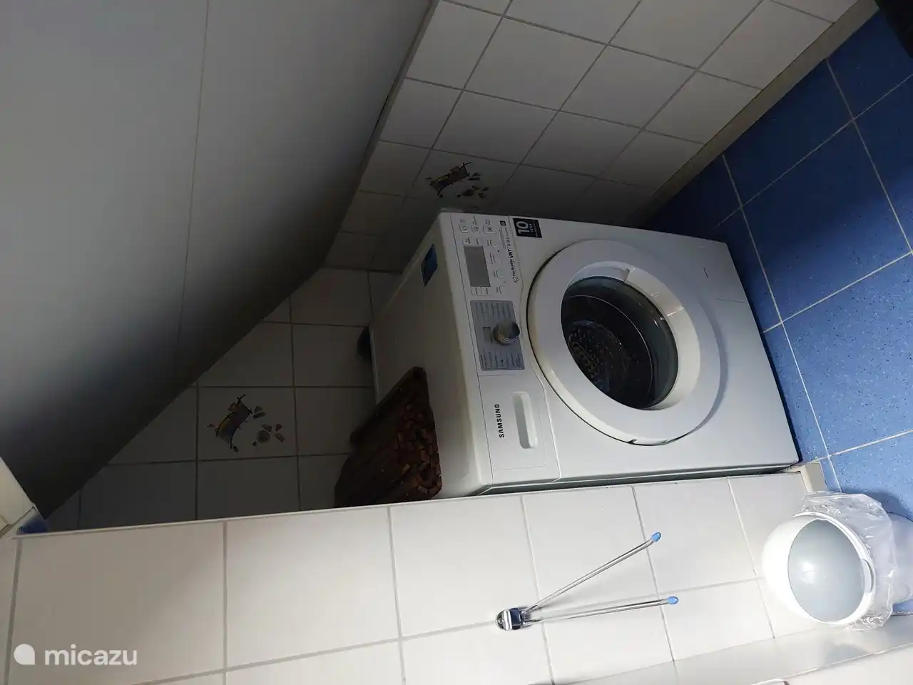 The washing machine is located in the bathroom. A drying rack is also available, as is an ironing board and iron.