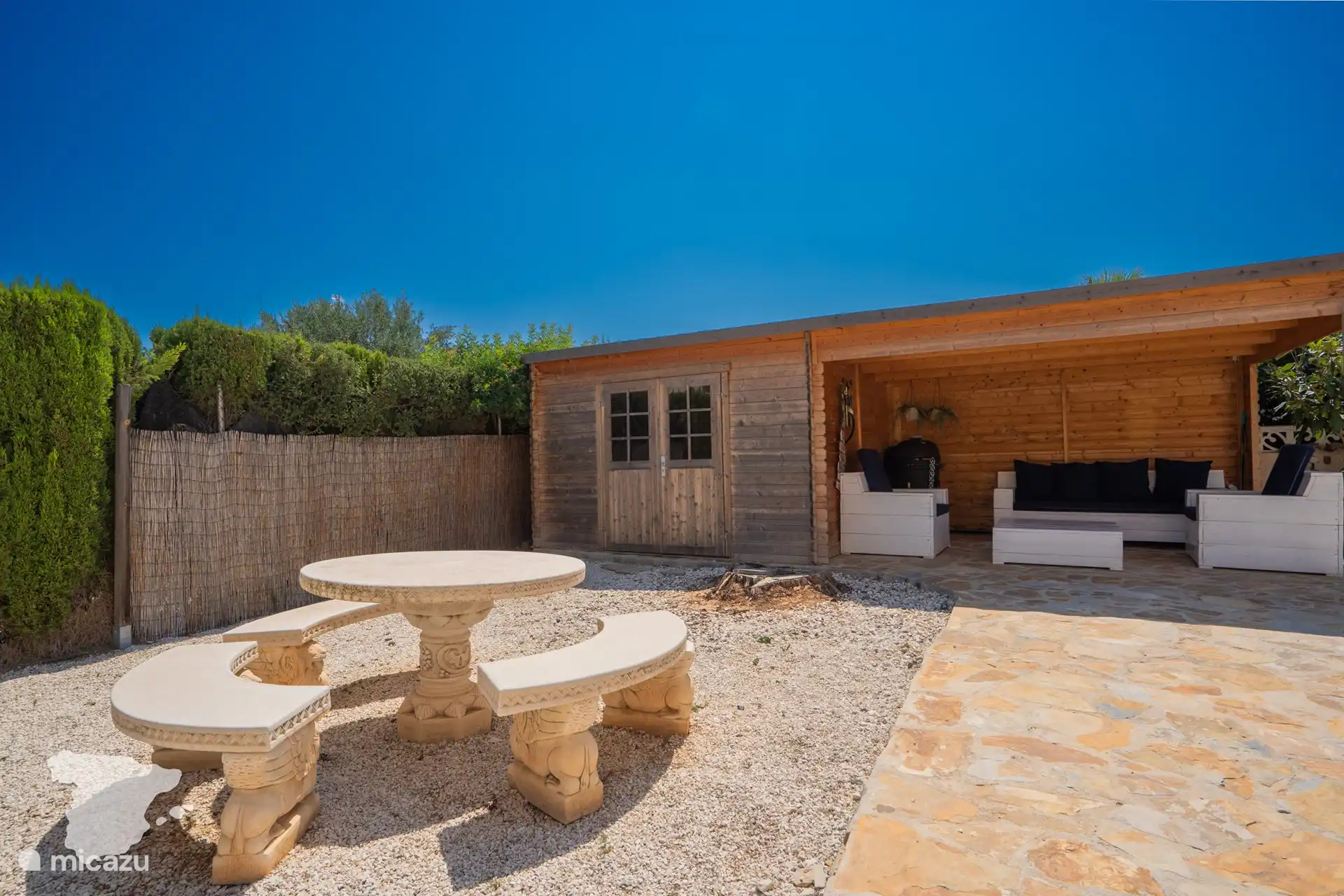 Sitzecke und dahinter ein Vordach mit Loungebereich