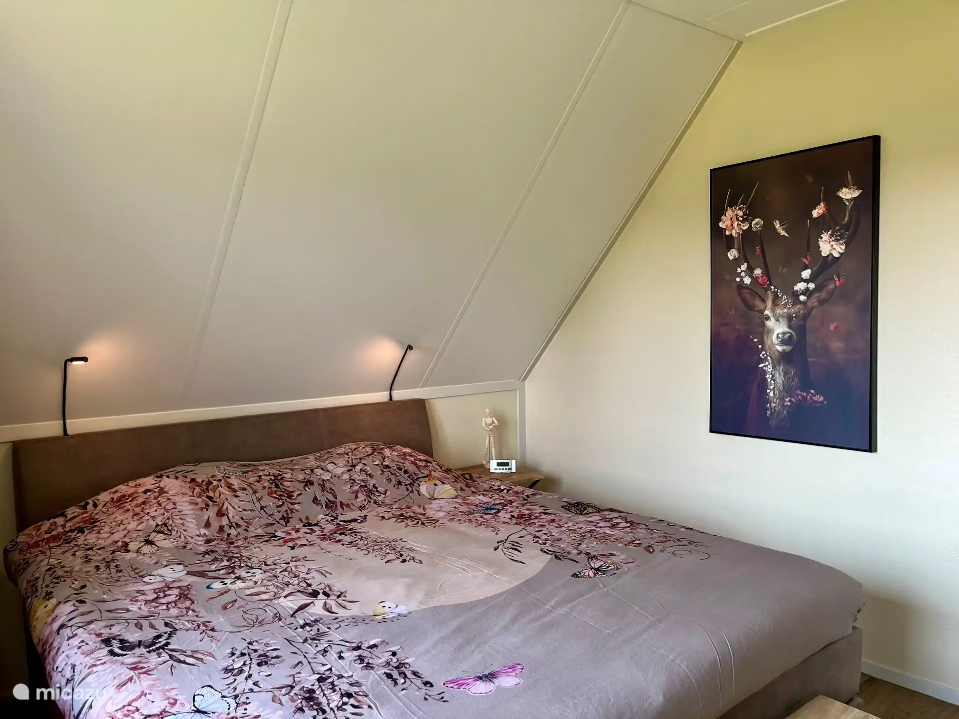 Hauptschlafzimmer mit großem Boxspringbett für 2 Personen 180x210, dimmbaren Leselampen, Innen-/Außenbeleuchtung, geräumigem Kleiderschrank mit Ganzkörperspiegel und Blick über die Wiese.