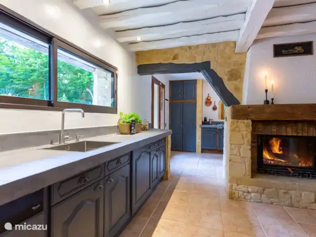 Maison de vacances de luxe avec piscine chaude | France, Dordogne, Rampieux - maison de vacances Cuisine avec cheminée et accès à la buanderie et à la terrasse extérieure