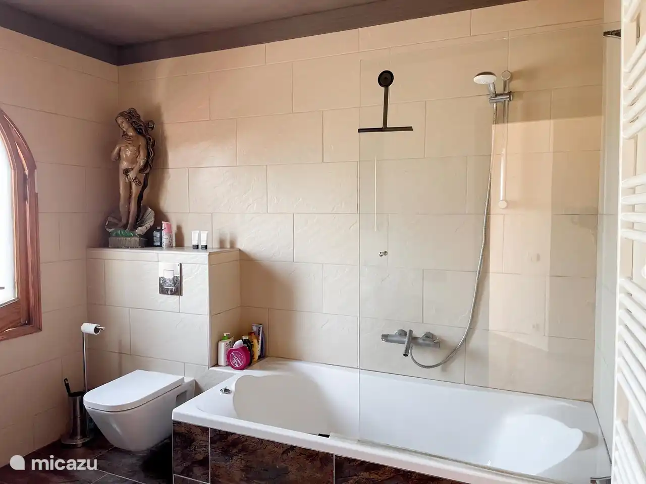 Das Badezimmer im ersten Stock ist sehr geräumig und verfügt über eine große Badewanne mit einem flachen Stehbereich für die Dusche.