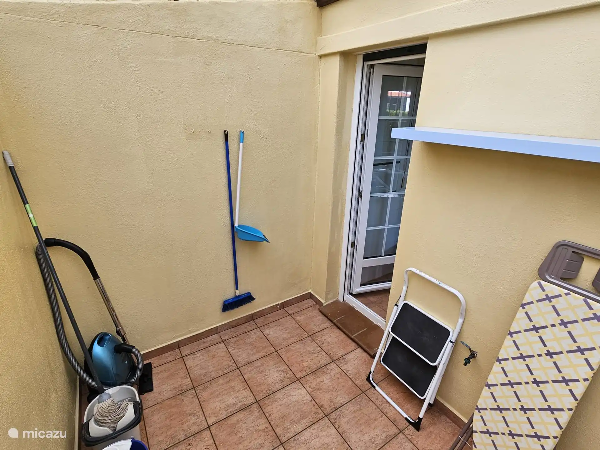 Hauswirtschaftsraum mit Waschmaschine, Bügelbrett und Bügeleisen