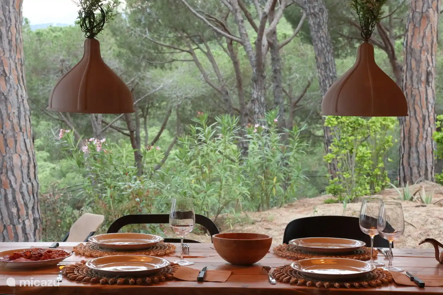 Esstisch im Freien auf einer überdachten Terrasse mit Blick auf die Skyline von Barcelona (sofern es natürlich nicht neblig ist).