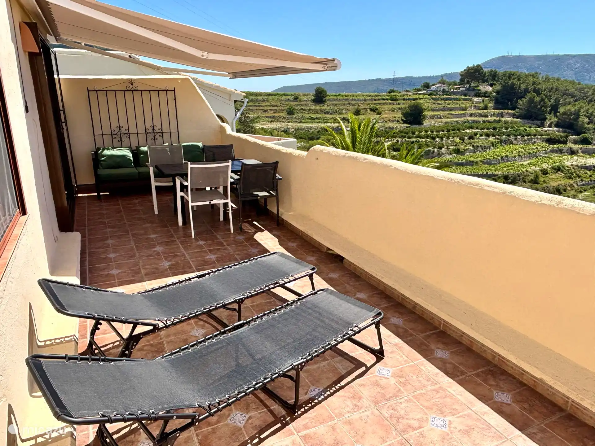 Balcony with luxury electric awning, terrace, bench and sunbeds.