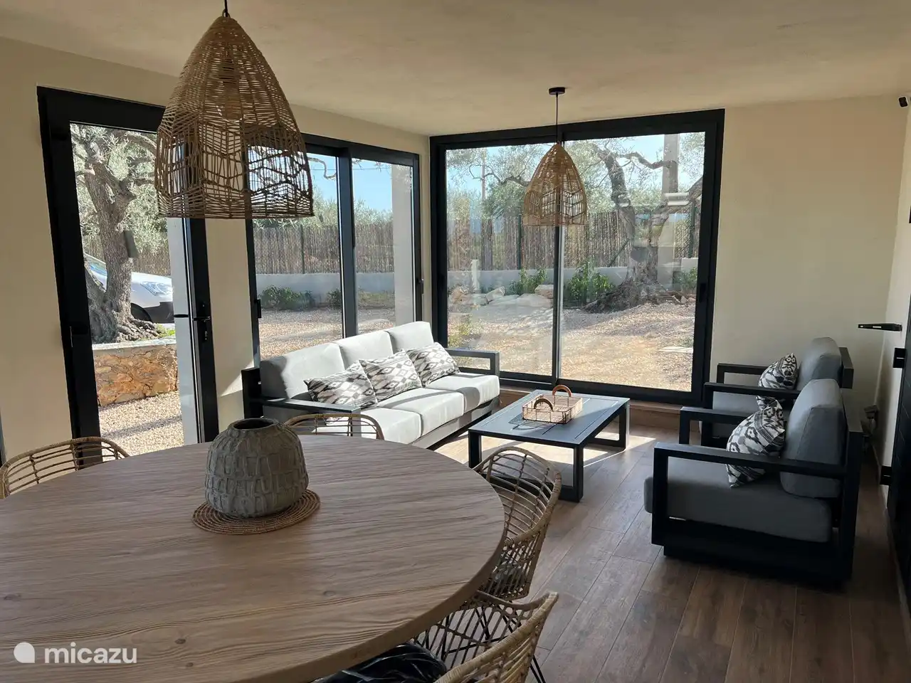 Ein bezaubernder Anblick entfaltet sich auf der Innenterrasse, die mit einem geräumigen Holztisch geschmückt ist. Mit atemberaubendem Blick auf den Garten und den Pool ist es ein idyllischer Ort, um bleibende Erinnerungen zu schaffen. Die perfekte Mischung aus Natur und Komfort lädt zu gemütlichen Zusammenkünften ein und umhüllt die Gäste in ein ruhiges und magisches Ambiente.