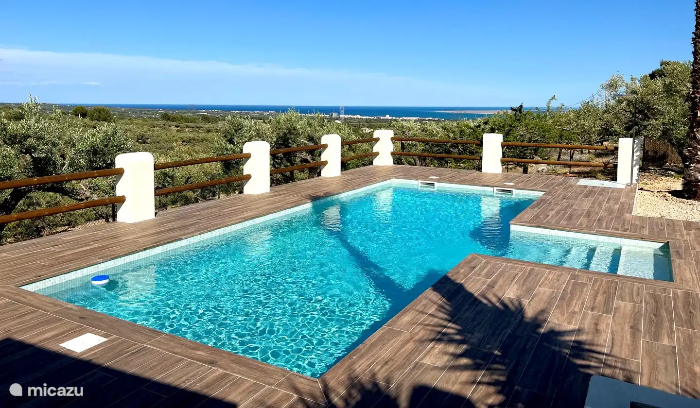 Vor Ihren Augen entfaltet sich eine Szene der Gelassenheit und Ehrfurcht, mit dem Pool im Mittelpunkt und der atemberaubenden Aussicht im Hintergrund, die Sie einlädt, in ein visuelles Paradies einzutauchen.