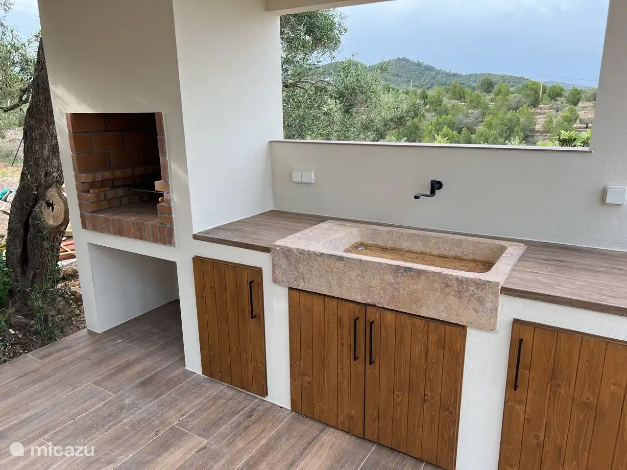 Ein einladendes Foto, das die perfekte Kombination aus einer Oase am Pool und einem Grill einfängt und die Kulisse für herrliche Zusammenkünfte im Freien bildet.