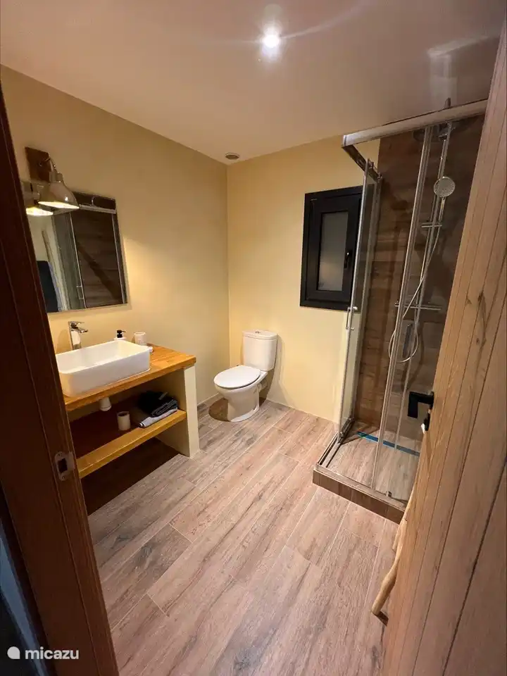 Ein kompaktes, aber dennoch erfrischendes Badezimmer mit einer bezaubernden kleinen Dusche, die dem Raum einen Hauch von Eleganz verleiht und für ein revitalisierendes und belebendes Badeerlebnis sorgt.