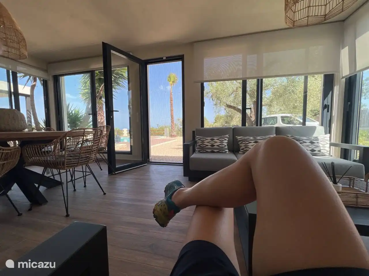 Ein bezaubernder Anblick entfaltet sich auf der Innenterrasse, die mit einem geräumigen Holztisch geschmückt ist. Mit atemberaubendem Blick auf den Garten und den Pool ist es ein idyllischer Ort, um bleibende Erinnerungen zu schaffen. Die perfekte Mischung aus Natur und Komfort lädt zu gemütlichen Zusammenkünften ein und umhüllt die Gäste in ein ruhiges und magisches Ambiente.