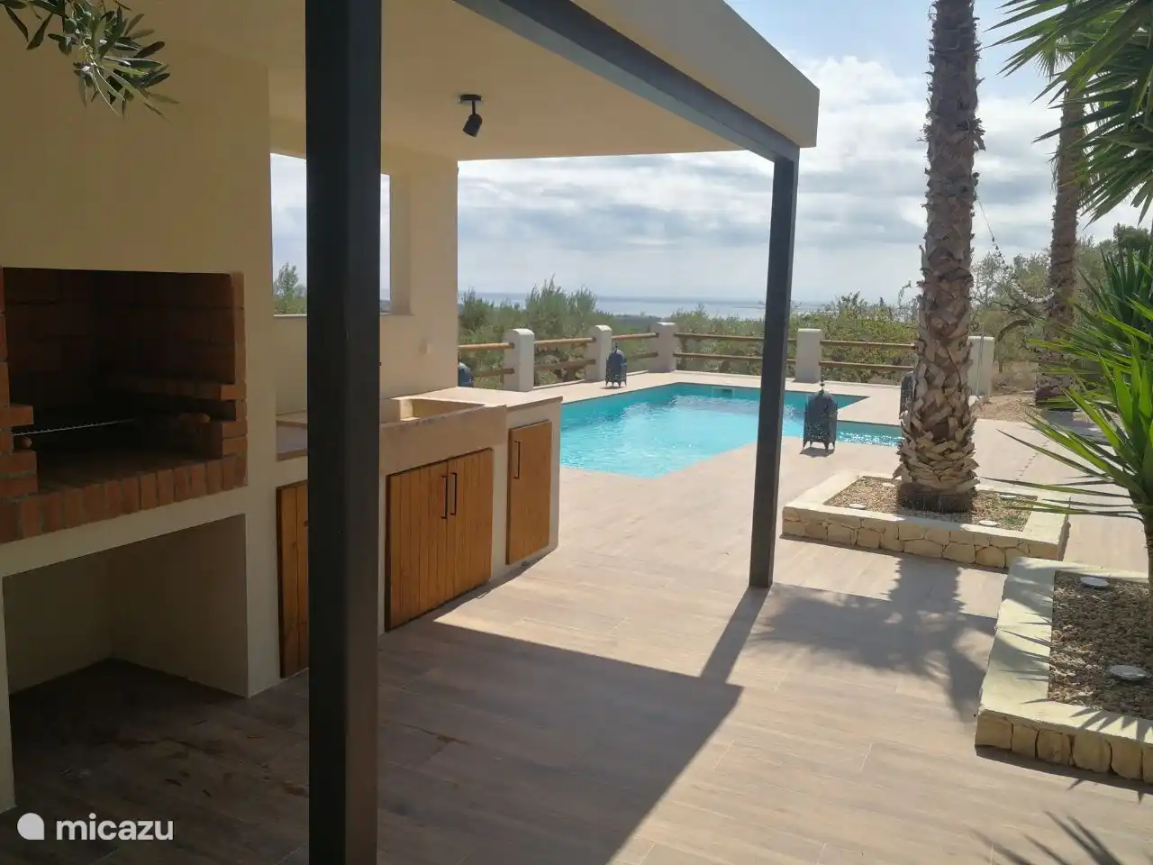 Ein einladendes Foto, das die perfekte Kombination aus einer Oase am Pool und einem Grill einfängt und die Kulisse für herrliche Zusammenkünfte im Freien bildet.