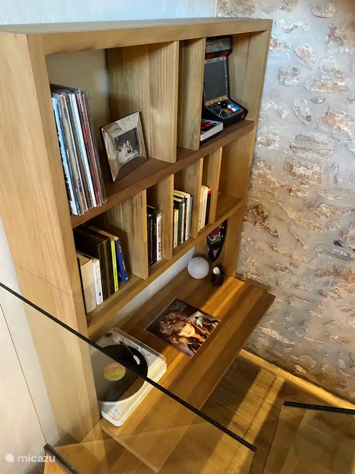 Dieser wunderschön gestaltete Schreibtisch ist eine ruhige Oase zum Lesen und Genießen von Musik und bietet den perfekten Rückzugsort. Tauchen Sie ein in eine Welt des Wissens und der Melodien, umgeben von einer friedlichen Atmosphäre, die Konzentration und Entspannung fördert. Ein Ort, an dem die Inspiration frei fließt und der Geist Trost findet.