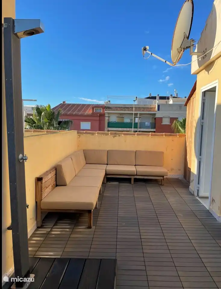 Dachterrasse mit Sofa und Kissen.
Ein Abstellraum mit Bügelbrett etc...