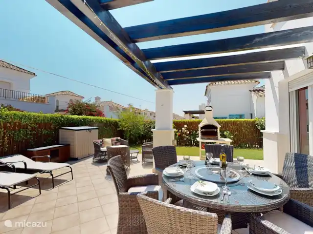 Casa Gofré | Espagne, Costa Cálida, Torre Pacheco - villa Terrasse derrière le salon avec 6 bains de soleil avec coussins, 6 chaises de salle à manger, table ronde avec plateau en verre, au milieu un plateau tournant en verre. barbecue. 2 bacs de jardin pour ranger les coussins de transat et de chaise.