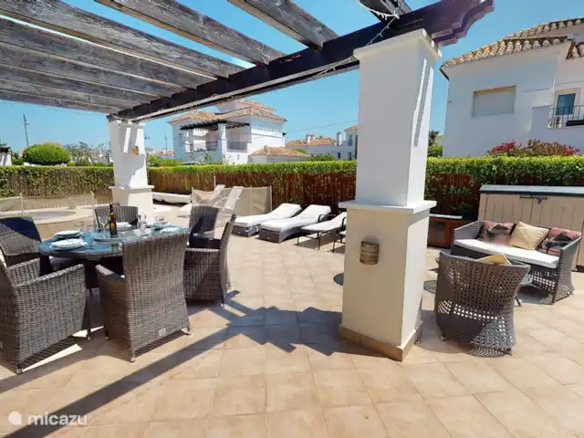 Casa Gofré | Espagne, Costa Cálida, Torre Pacheco - villa Terrasse derrière le salon avec 6 bains de soleil avec coussins, 6 chaises de salle à manger, table ronde avec plateau en verre, au milieu un plateau tournant en verre. barbecue. 2 bacs de jardin pour ranger les coussins de transat et de chaise.