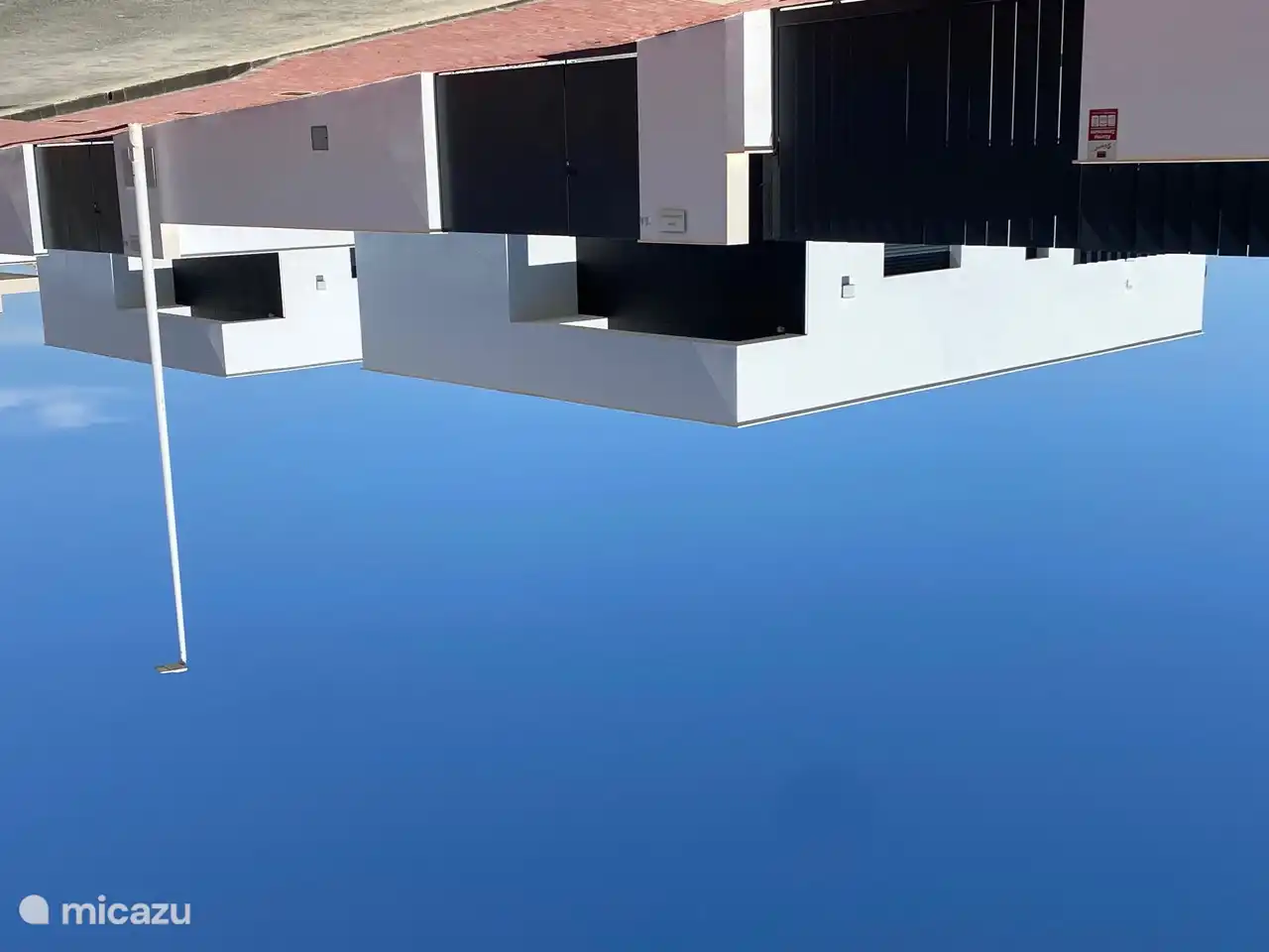 Lado de la calle de las villas. Aparcamiento en frente de la villa.