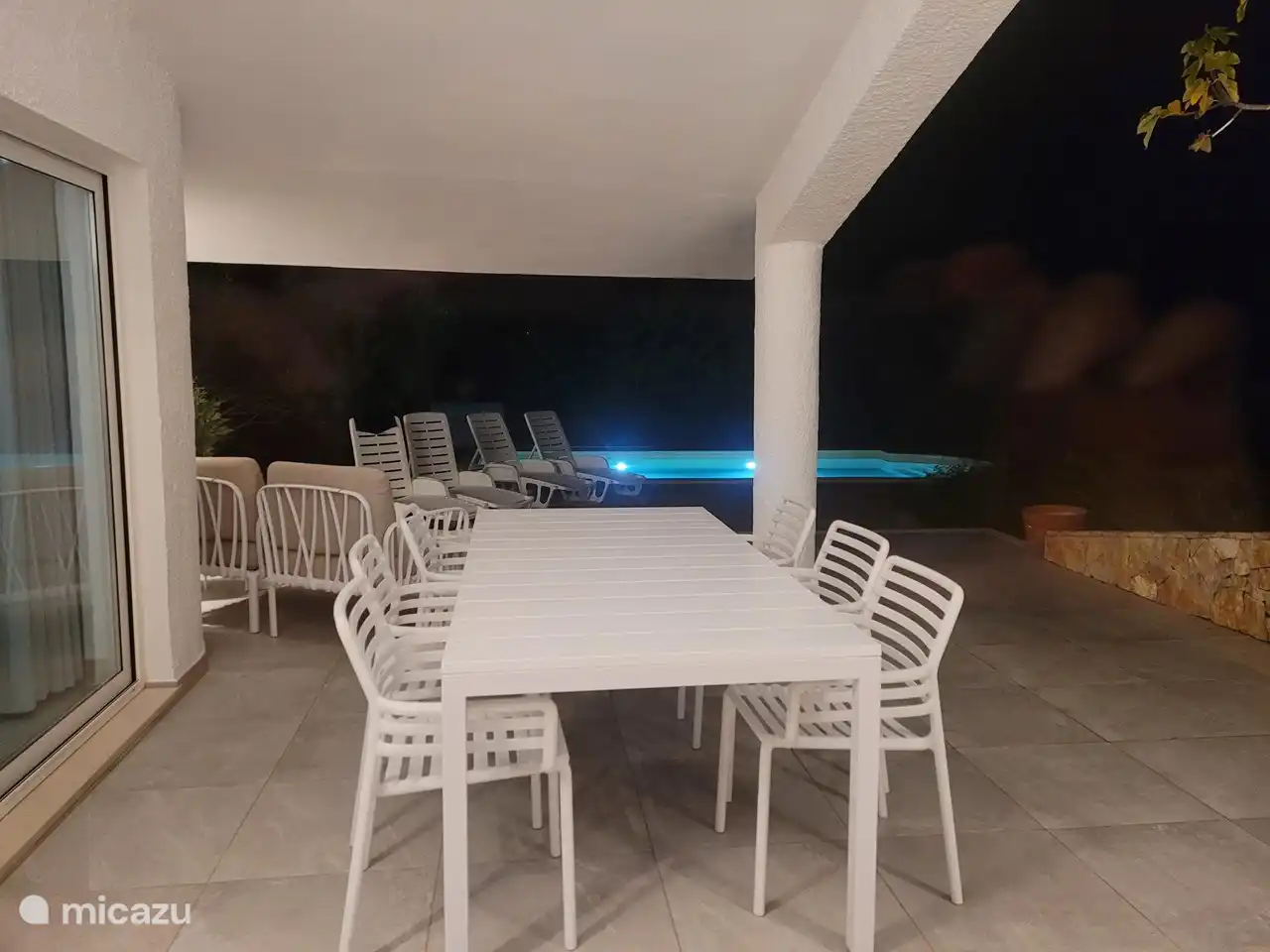 Terraza con piscina iluminada por la noche