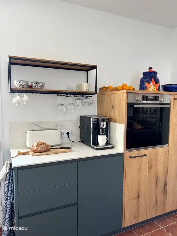 Die Küche ist mit einer Frühstücksecke ausgestattet. Induktionskochfeld, Geschirrspüler, großer Kühlschrank, Gefrierschrank und Backofen.