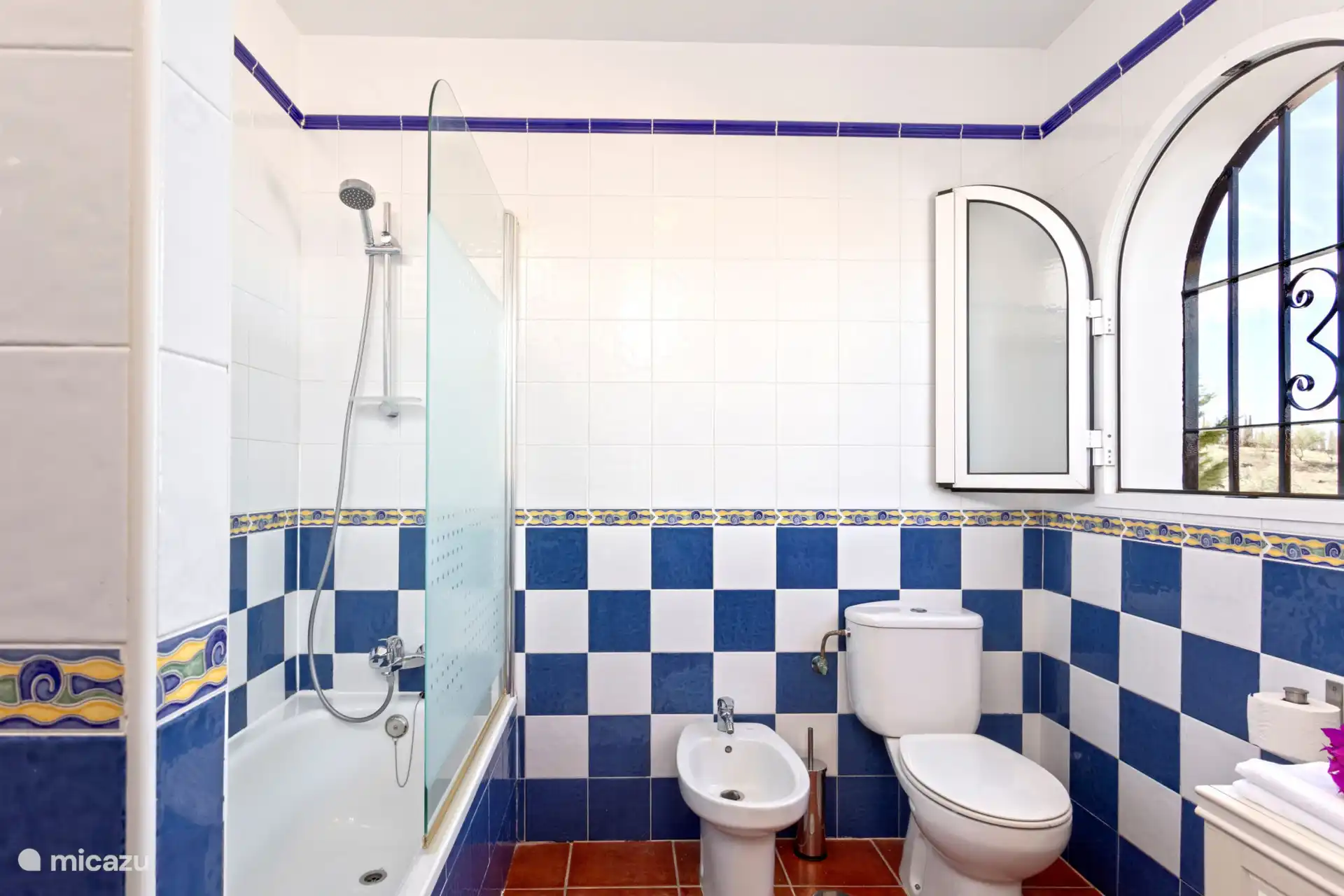 Équipé d’une baignoire avec douche au-dessus, des toilettes, un lavabo et un sèche-cheveux.