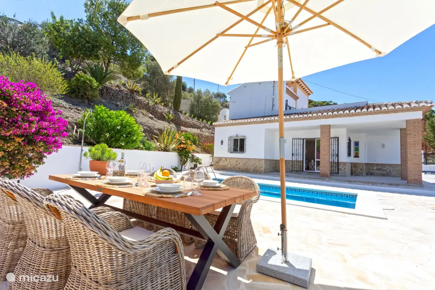 Ein Esstisch mit Sonnenschirm, damit Sie auch leicht Schatten finden können (jetzt unter der neuen Veranda)