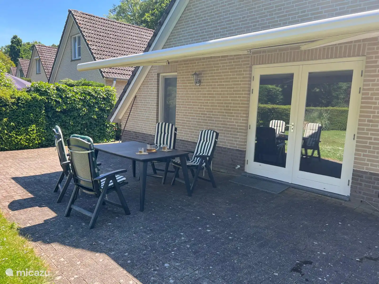 Terras aan het huis met zonnescherm
