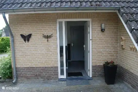 Flur mit Türen zur Toilette, Dusche und Wohnzimmer und Treppe nach oben.