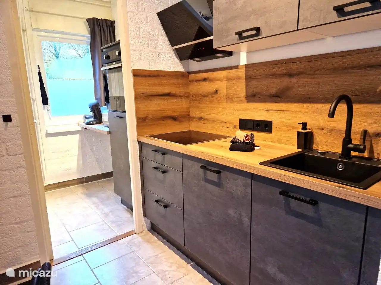 Küche und Hauswirtschaftsraum mit Geschirrspüler, großem Backofen und großer Kühl-/Gefrierkombination, Stauraum, Elektroherd, Dunstabzugshaube, Steckdosen, Küchenutensilien, Wasserkocher, Kaffeemaschine.