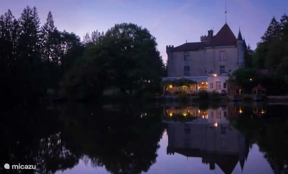 Castillo Le Verdoyer con estanque de peces al atardecer