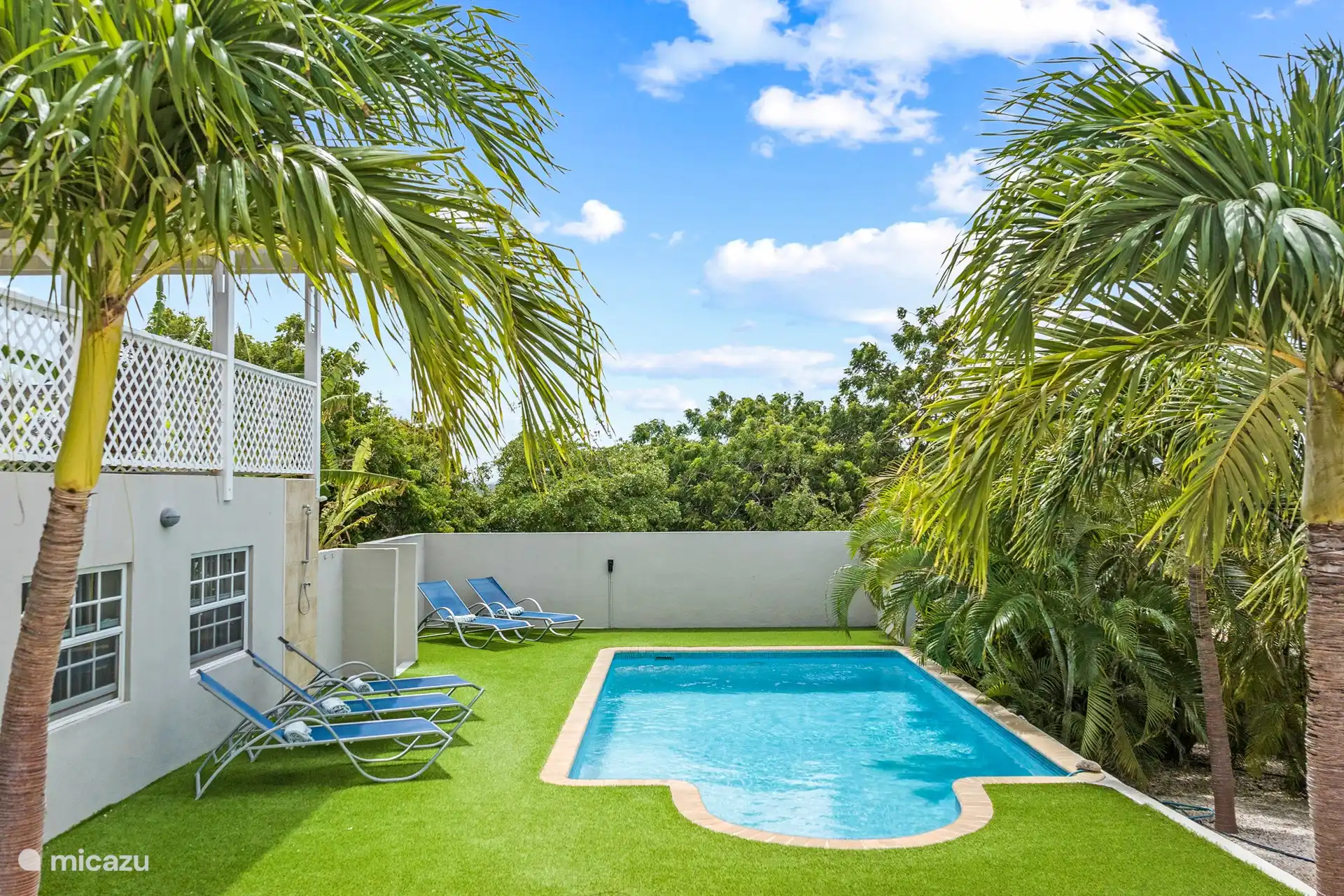 Neem plaats op een van de ligstoelen bij het zwembad en laat de zonnestralen op uw gezicht schijnen.