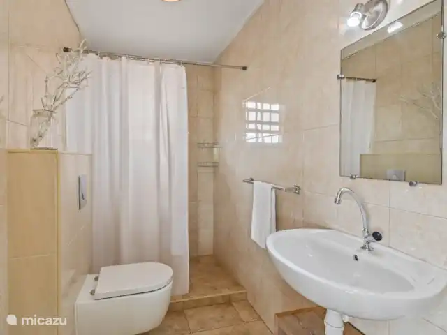 Casa Rubus | Curaçao, Banda Ariba (est), Vista Royal - villa Dans la salle de bain commune, vous trouverez une douche spacieuse, un lavabo et des toilettes. Des serviettes et des serviettes de plage sont également fournies, vous n’avez donc pas à trimballer des bagages supplémentaires. De plus, de l’eau chaude est toujours disponible, ce qui vous permet de vous détendre après une longue journée de visites