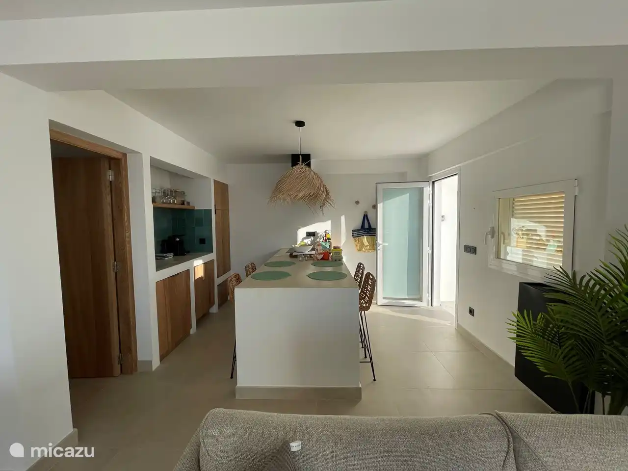 Open kitchen in Ibiza style with induction hob, oven, fridge with freezer compartment, dishwasher, Nespresso machine and juicer.