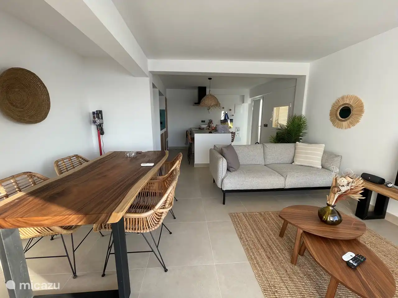 Living room with wooden tree trunk table and 4 rattan chairs.