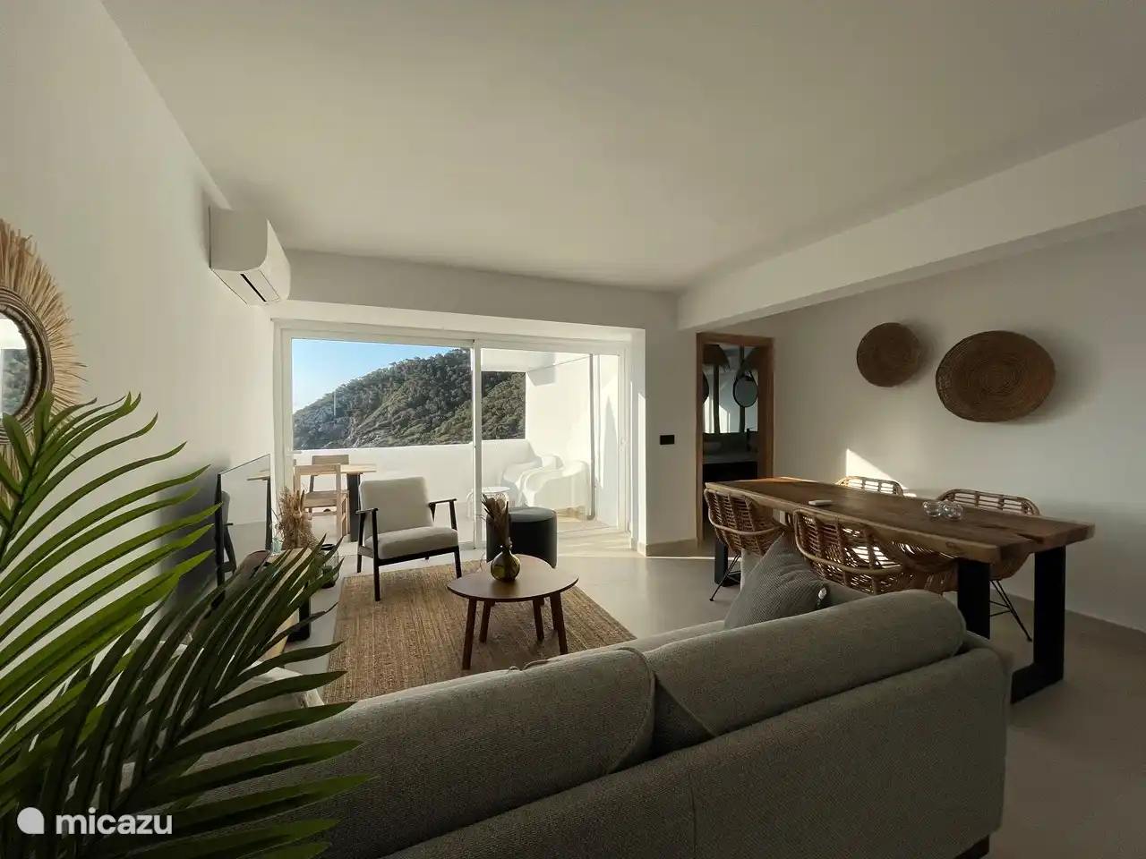 Cozy furnished living room that opens onto the terrace with an unobstructed view of the bay and the sea.