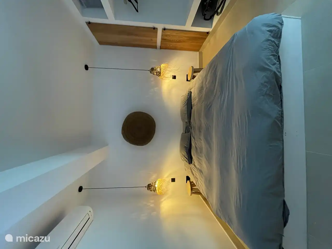 Room 2 with double bed and built-in cupboard with washing machine and dryer. This room has an en suite bathroom and is equipped with Daikin air conditioning.