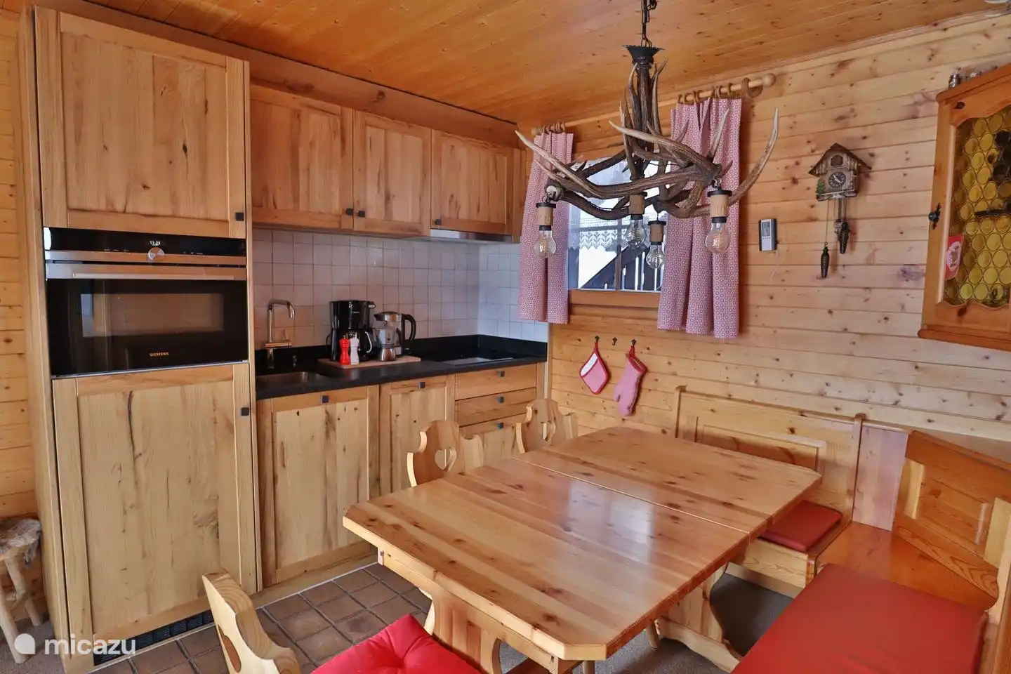 grote woonkamer met volledig gerenoveerde eikenhouten keuken in 18 met moderne inbouwapparatuur en een ouderwetse speksteenkachel, ruime comfortabele zithoek.