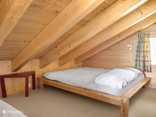 Location de Vacances Suisse, Valais, Bettmeralp, appartement - Fata Morgana 6 Galerie de couchage ouverte dans le toit en pente, avec un lit français et un lit d'appoint.