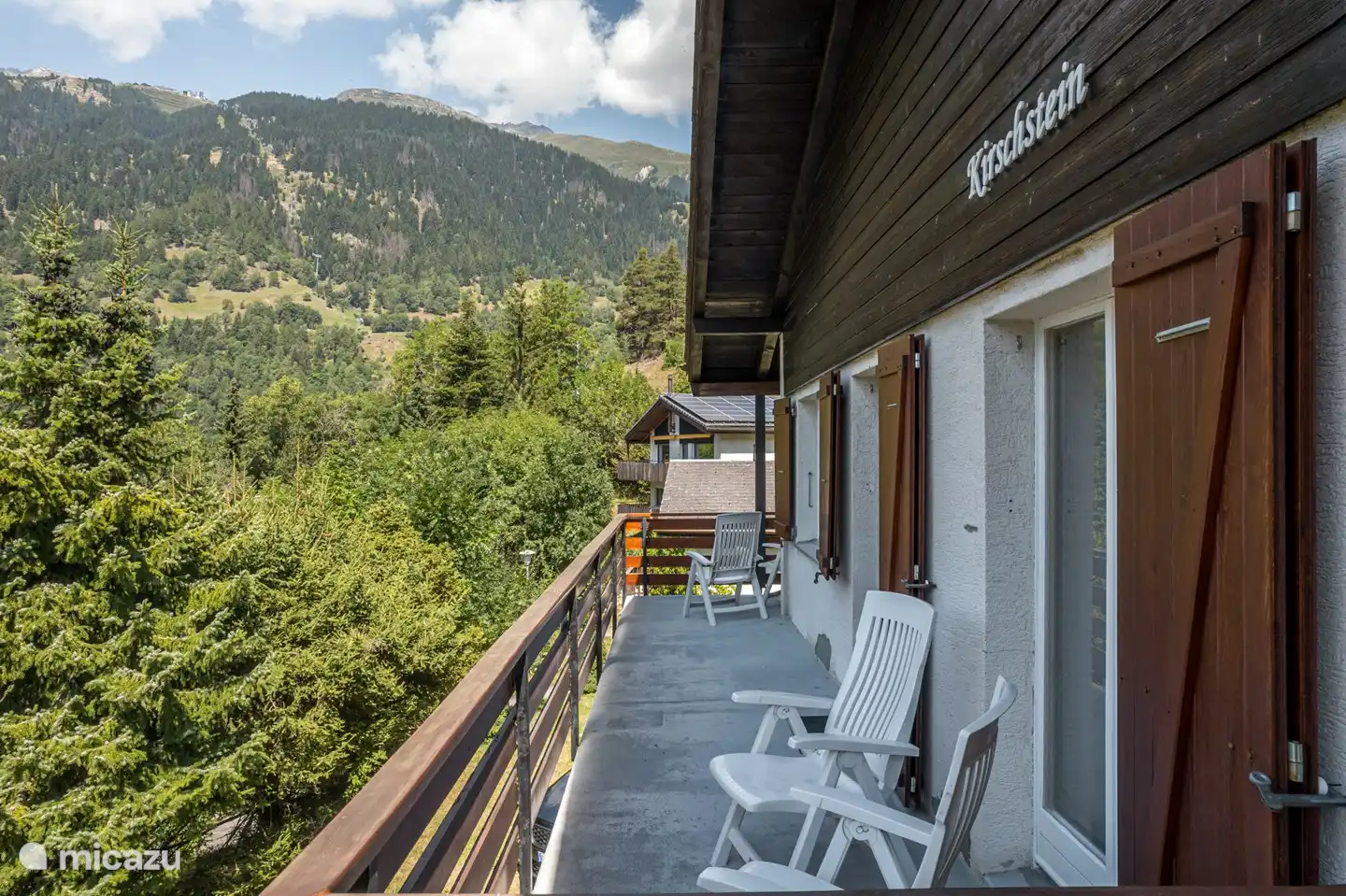 Balcon à l'avant et terrasse avec chaises de jardin de part et d'autre de la chambre haute