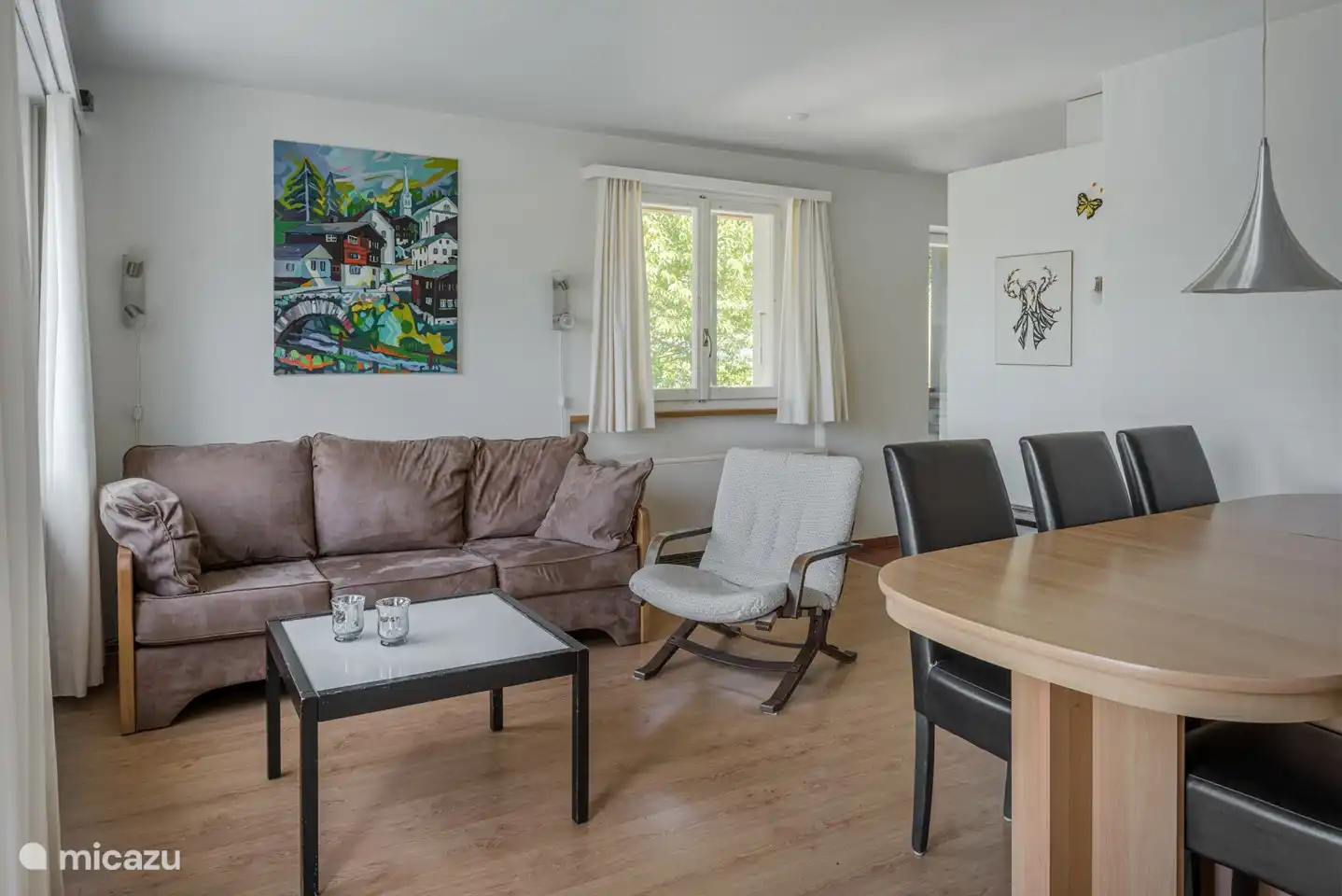Salon-salle à manger avec portes-fenêtres donnant sur le balcon.