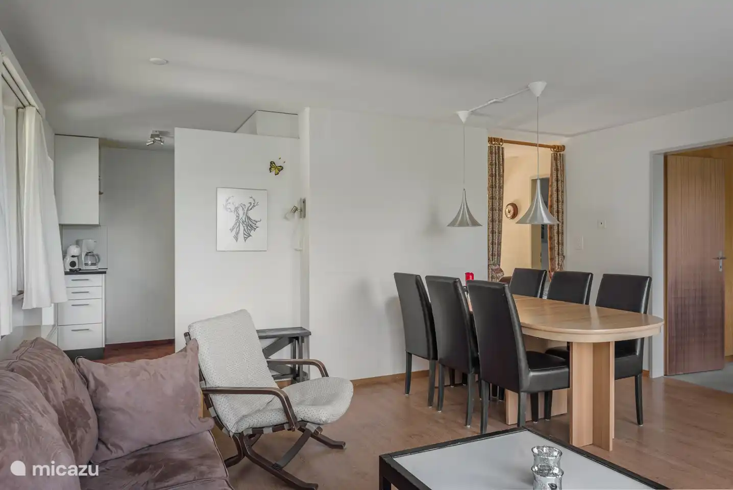 Salon-salle à manger avec portes-fenêtres donnant sur le balcon.