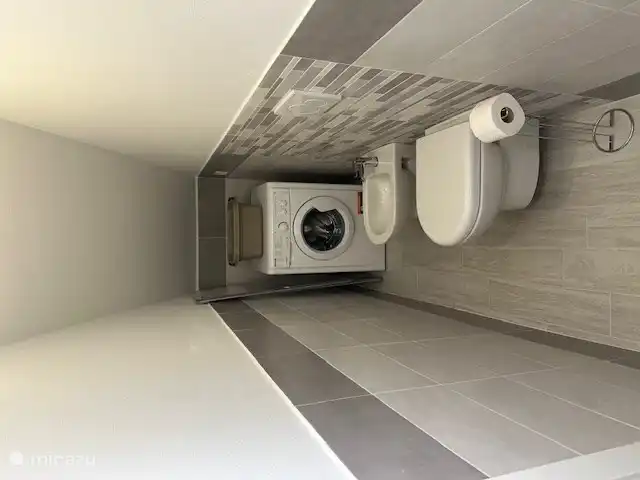 pequeño cuarto de baño con inodoro, bidet, lavabo y lavadora