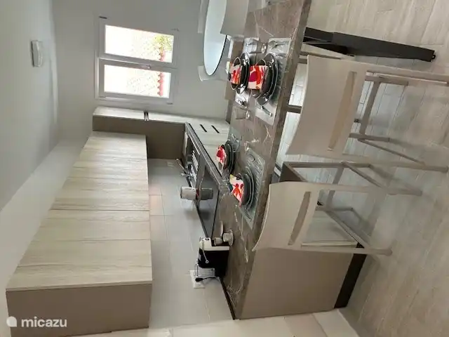 cocina con mesa y sillas altas