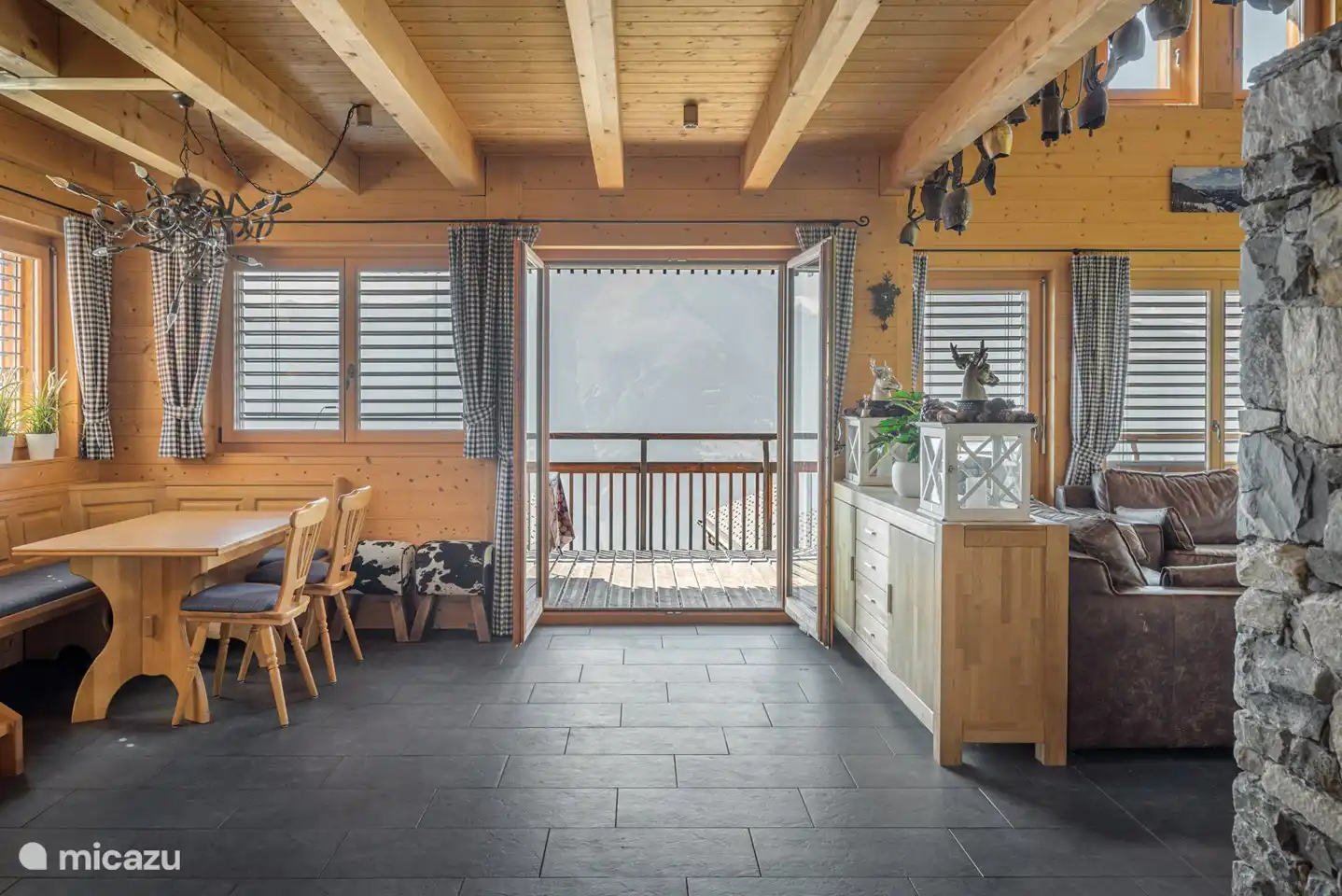 Wohnzimmer mit Essecke und offener Küche, offenen Kamin und Südwest-Balkon.