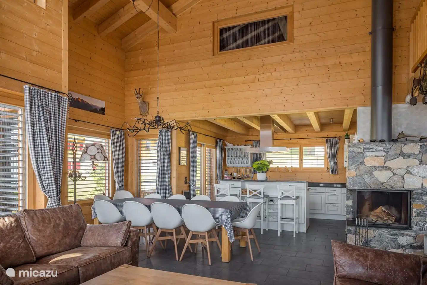 Wohnzimmer mit Essecke und offener Küche, offenen Kamin und Südwest-Balkon.