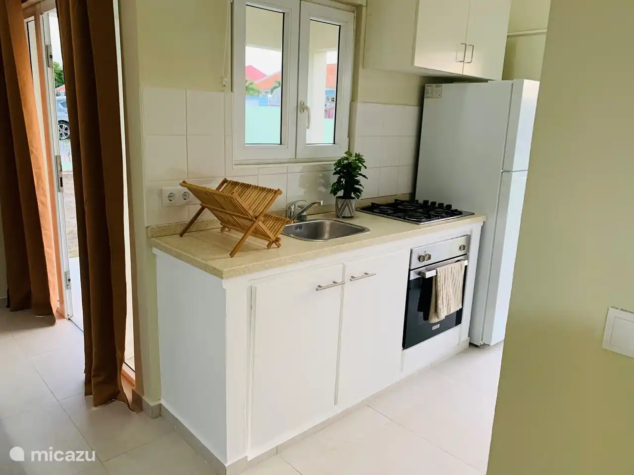 Kitchen with a gas stove and oven and a coal. Furthermore, the kitchen is equipped with all necessary kitchen utensils and a microwave.