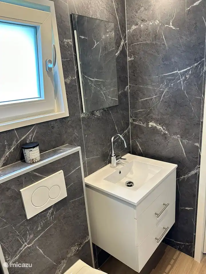 Badezimmer mit Dusche, Toilette und Waschbecken.