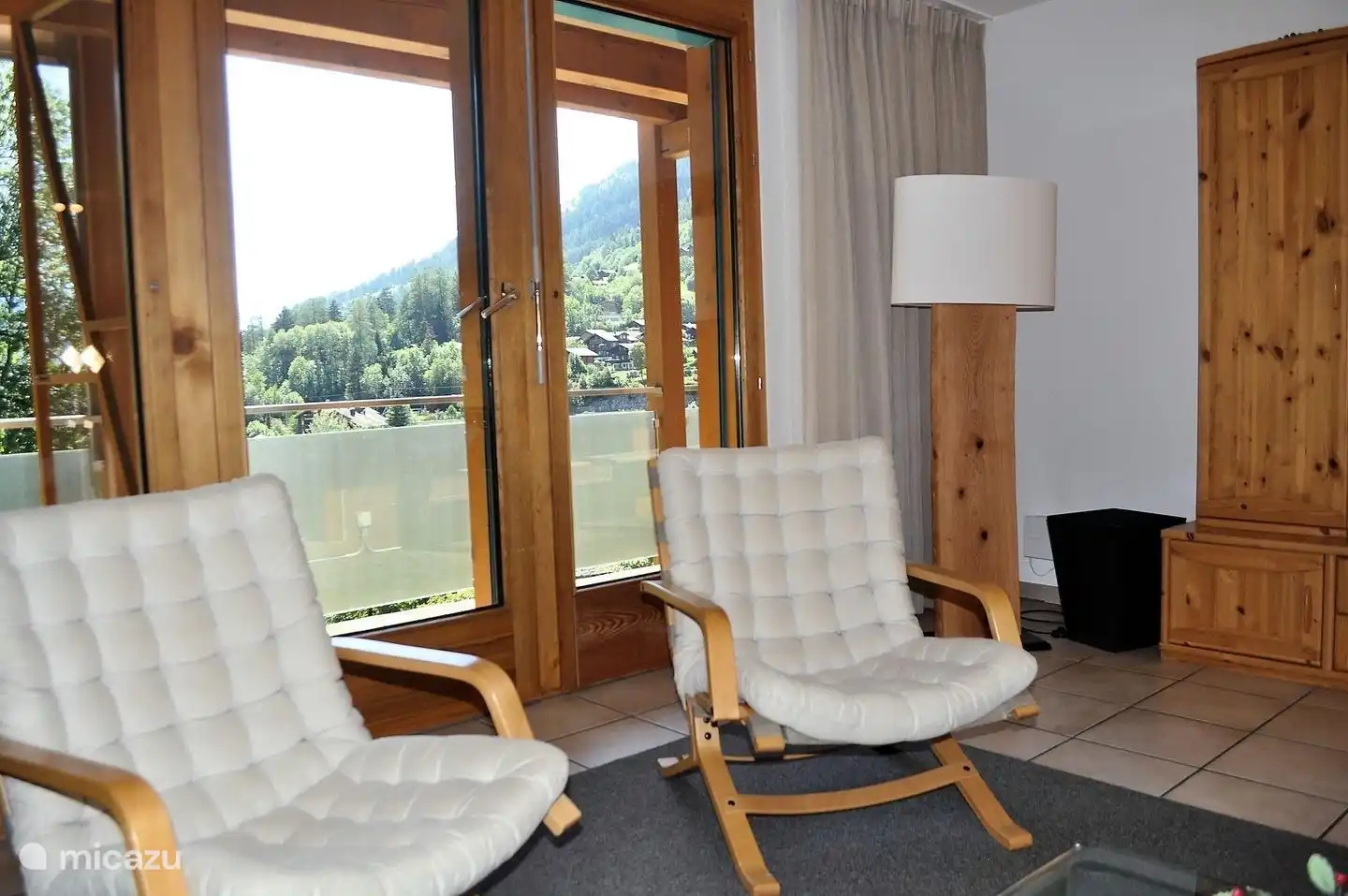 Das geräumige Wohnzimmer bietet durch große Fenster einen Blick auf das gesamte Tal