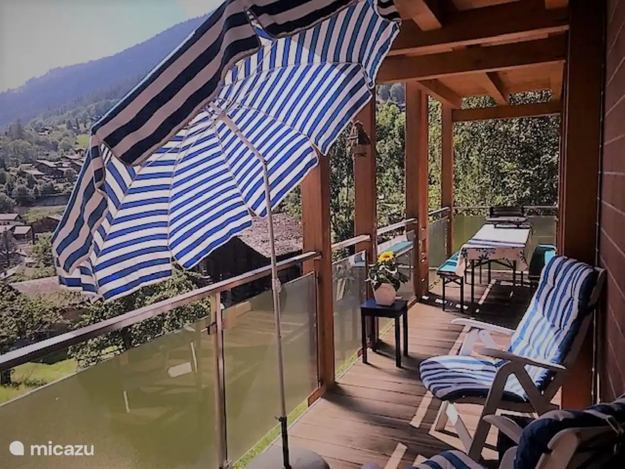 Der Balkon erstreckt sich über die gesamte Länge der Wohnung. Mit langen Tischen und Bänken und separaten Stühlen gibt es Sitzplätze für alle.