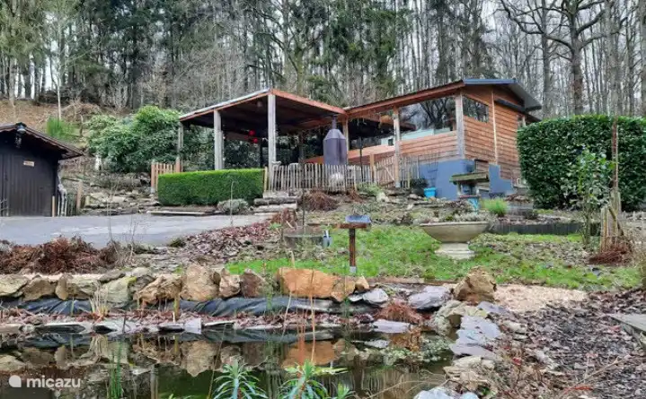Das Ferienhaus liegt etwas höher auf dem Grundstück mit Blick auf den Teich und den Wald