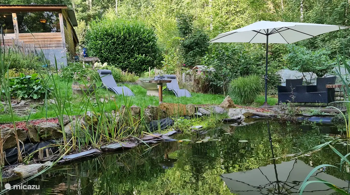 Genießen Sie die Sonne auf einer der Sonnenliegen am Teich