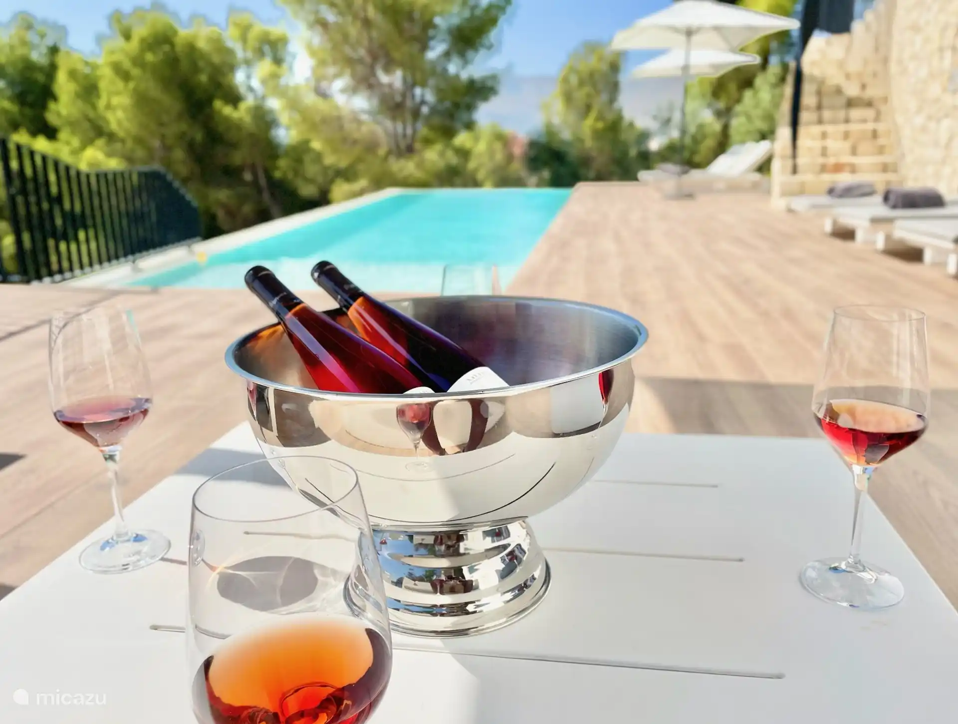 Zwembad terras met loungeset, ligbedden en parasols.